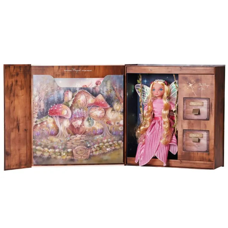 An open wooden case from the My Forever Tooth Fairy Gift Set reveals a fairy doll with long blonde hair, dressed in a pink outfit and adorned with transparent wings. The left side of the case showcases a dreamy illustration of an enchanting forest complete with toadstool houses. On the right side, three small drawers are positioned next to the doll, making it perfect for storing keepsakes or serving as an ideal Tooth Fairy gift box.