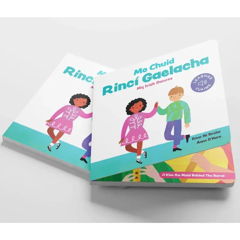 The illustrated children's book "Mo Chéad Rincí Gaelacha" shows two kids céilí dancing and holding hands on a colorful cover with Irish text and musical notes, celebrating cultural learning.