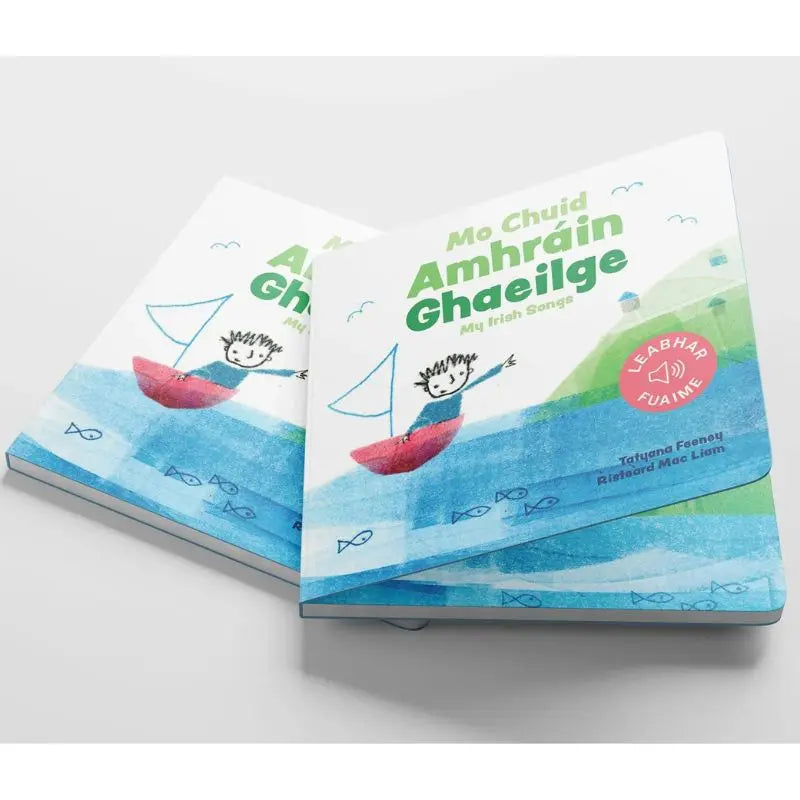 Mo Chuid Amhráin Ghaeilge" is a charming illustrated Irish-language songbook for toddlers, featuring a child in a red boat on blue water with fish and green hills—perfect for early Irish learning.
