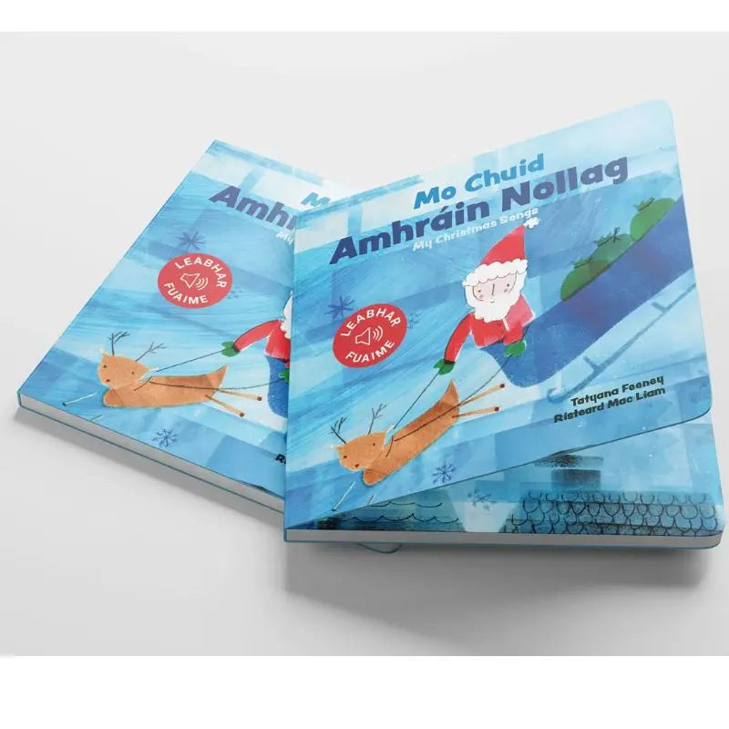 Mo Chuid Amhráin Nollag - New Edition" is an illustrated children’s book featuring Santa on a sleigh with a reindeer, introducing young readers to Irish-language Christmas songs and festive music.