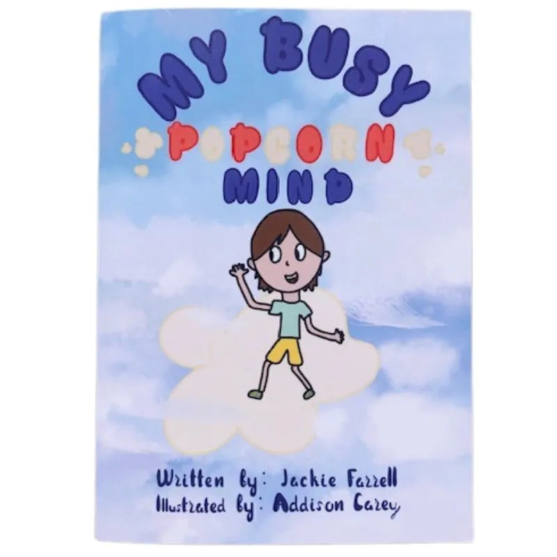 A book cover titled "My Busy Popcorn Mind" shows an illustration of a smiling child in yellow shorts and a green shirt, standing on a popcorn-shaped cloud. This delightful children's book set against a sky-blue backdrop with fluffy white clouds promotes mindfulness. Text credits author Jackie Farrell and illustrator Addison Carey.