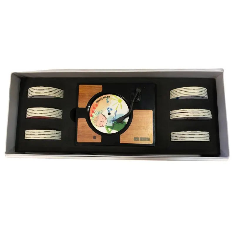 The Mini Gramophone Box Set includes a wooden music box styled as a mini record player with a decorative top disc and eight white-striped circular discs in side slots—ideal for enjoying traditional Irish songs.