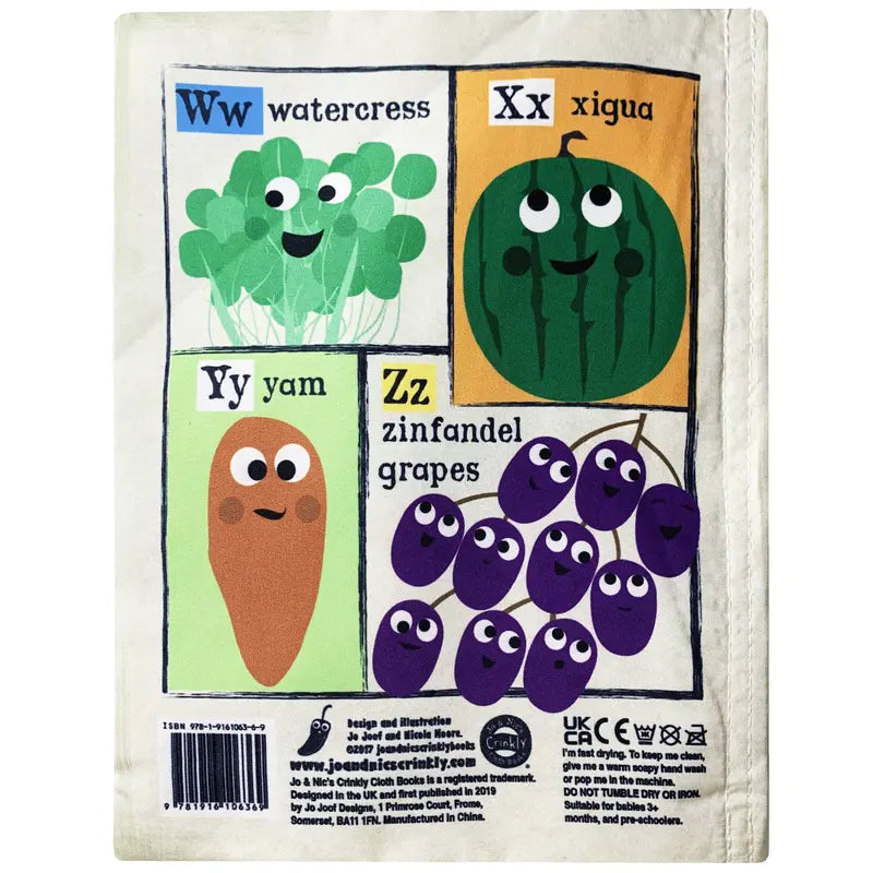 A vibrant page from the Crinkly Cloth Book Fruit & Veg features a smiling watercress, xigua (watermelon), yam, and zinfandel grapes labeled Ww, Xx, Yy, and Zz on a cream-colored background.