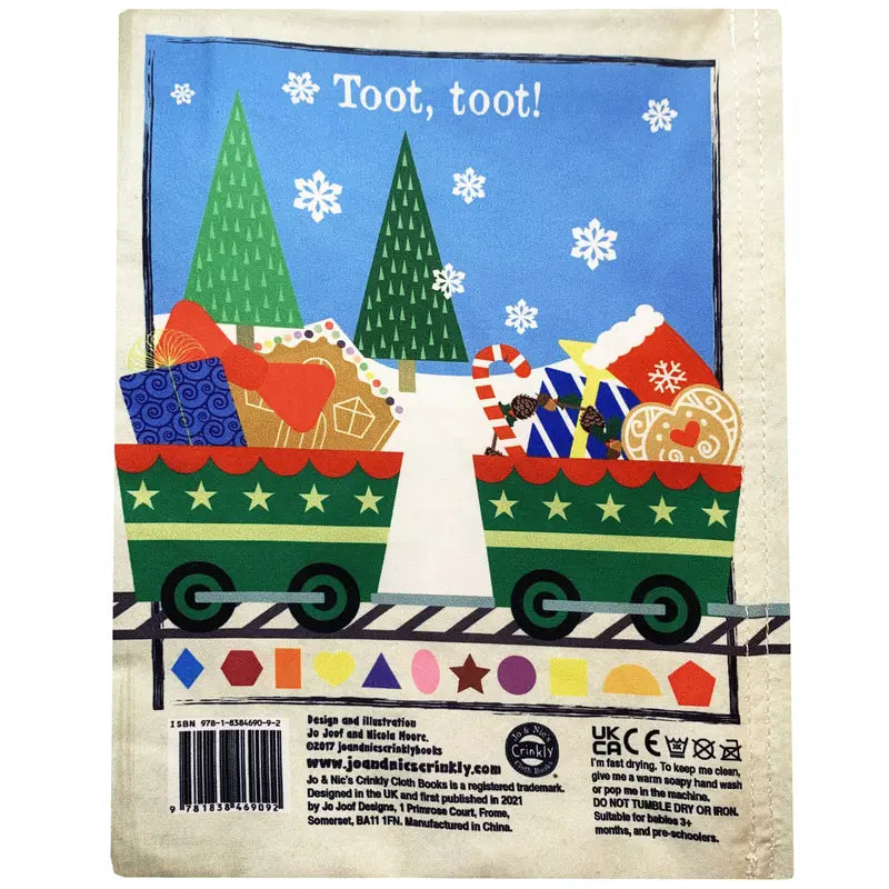 Two green train cars filled with gifts and toys travel on snowy tracks in this festive scene, with pine trees and falling snowflakes. Crinkly Cloth Book Christmas Shapes is a charming holiday gift for any cloth book lover!.