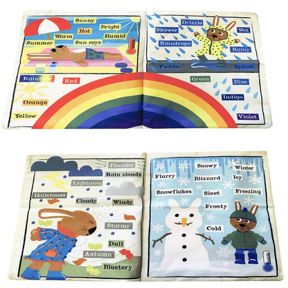 The Crinkly Cloth Book All Kinds Of Weather features colorful illustrations and labels for rainbows, sun, raindrops, a rabbit with an umbrella, clouds, snowflakes, and hail—helping little learners explore weather types and colors.