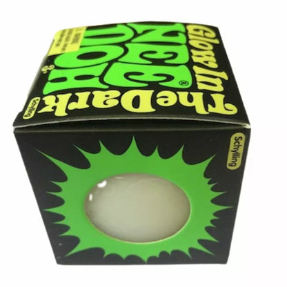 A Glow In The Dark Needoh Rubik's cube in its original packaging, featuring vibrant green accents and a clear window displaying one yellow side of the cube.