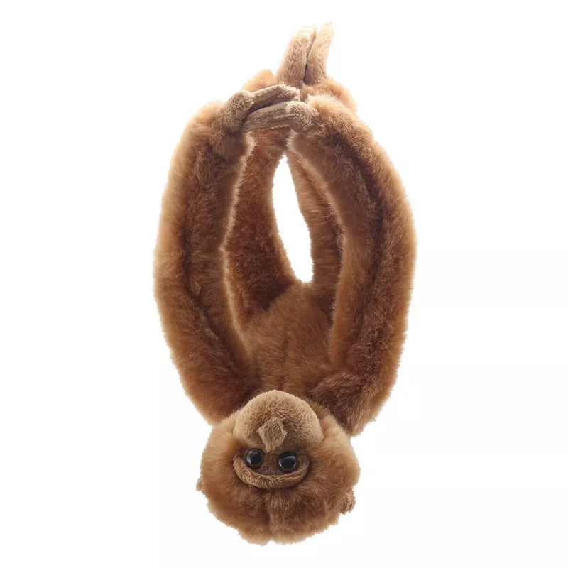 Sentence with product name: A soft toy of a brown Orangutan Canopy Climber hanging upside down, with a cute expression and fluffy fur.