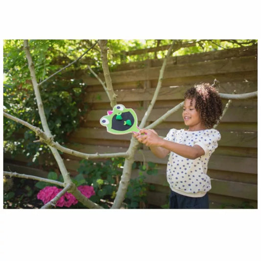 A little girl playing with a Buitenspeel Gecko Racket in a tree.