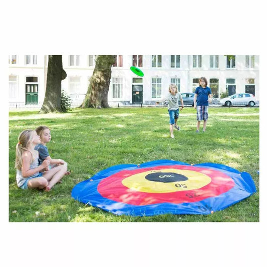 A group of children playing with a Buitenspeel Disc Deluxe Throwing Game in the grass.