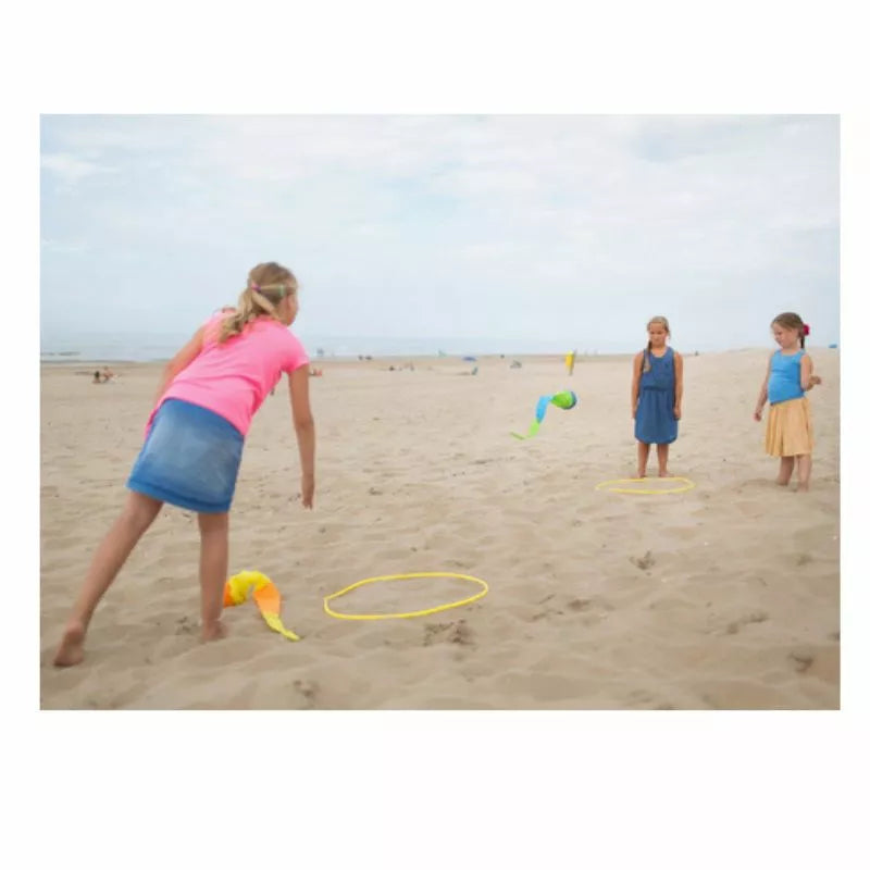 A group of children playing Buitenspeel Slingball Throwing Game on the beach.