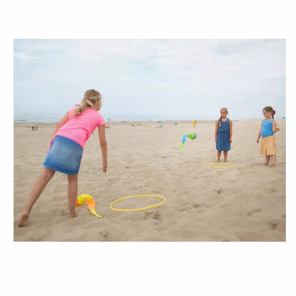 A group of children playing Buitenspeel Slingball Throwing Game on the beach.