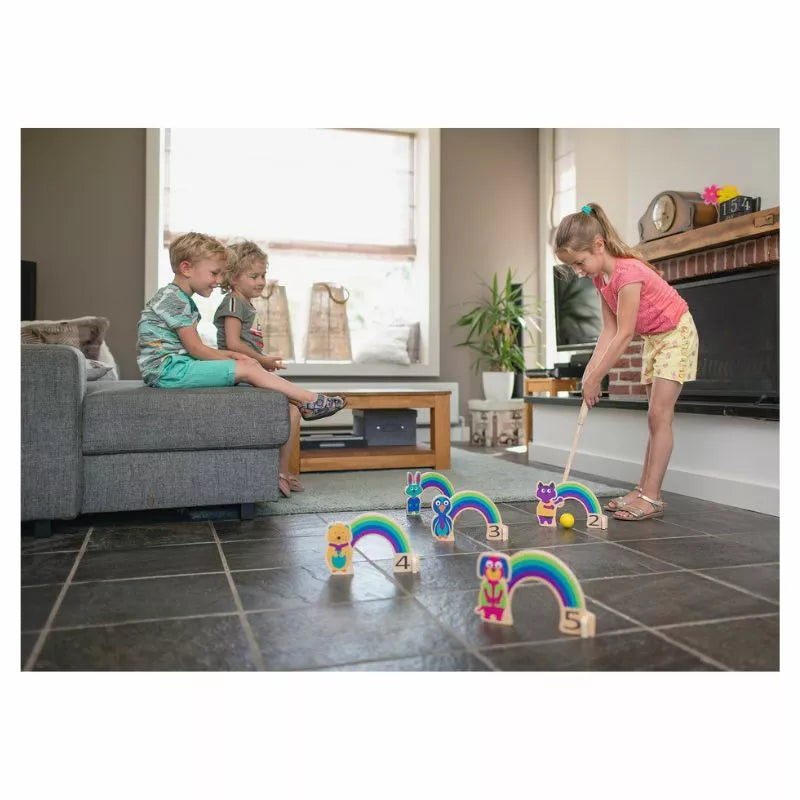 Two children playing with the Buitenspeel Rainbow Croquet in a living room.