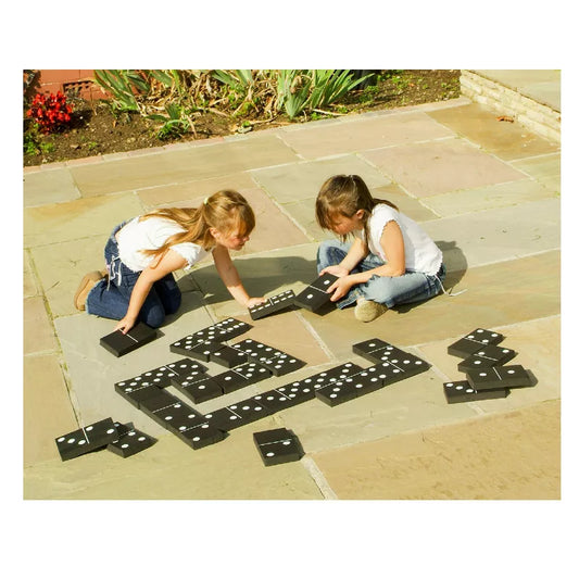 Two young girls playing with Black and White Dominoes on the ground.