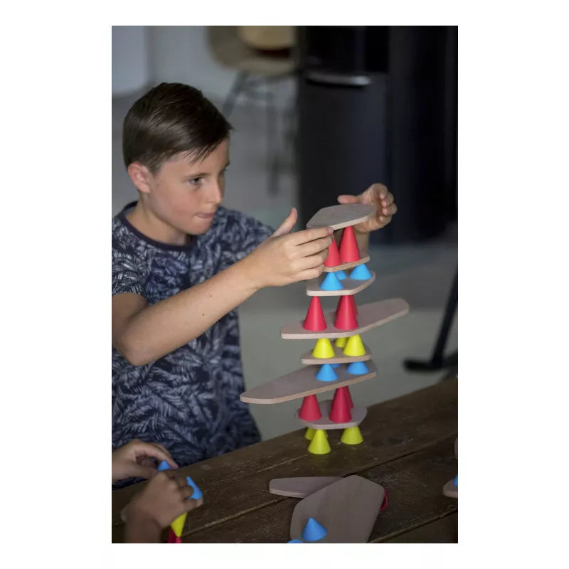 A young boy playing with a Piks Construction Big Kit – 64 pieces tower.