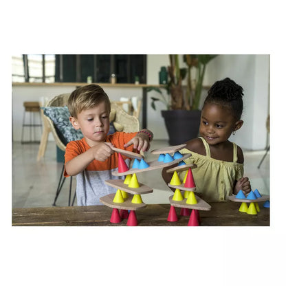 Two young children playing with the Piks Construction Medium Kit on a table.
