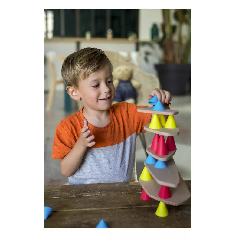 A young boy playing with a Piks Construction Small Kit stacking tower.