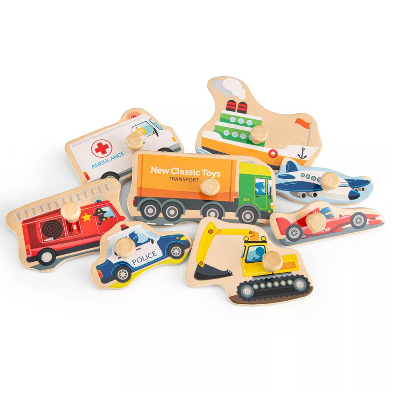 A pile of New Classic Toys Peg Puzzle - Transport - 8 pieces sitting on top of a white surface.