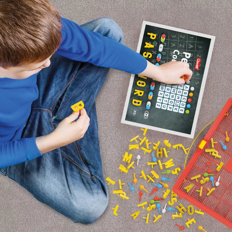 A young boy sitting on the floor playing with Quercetti Peg Code.
