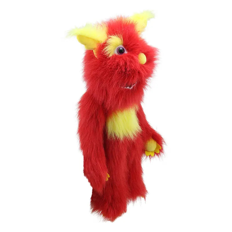 Standing upright, The Puppet Company Red Monster puppet is a vibrant and furry creation. It features bright red fur complemented by yellow accents on its ears, chest, and hands. Its large, expressive eyes convey a cheerful and playful demeanor, capturing the delightful charm of Monster Puppets.