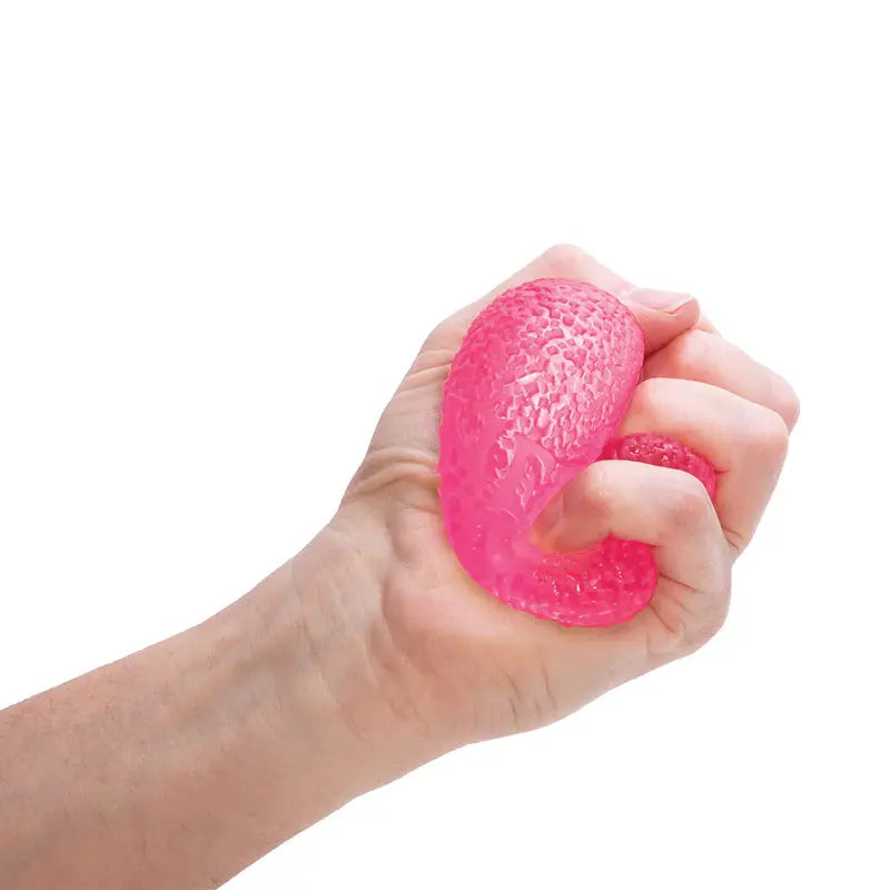 A hand squeezing a textured pink Gumdrop Needoh stress ball, a popular fidget toy for stress relief, against a white background.