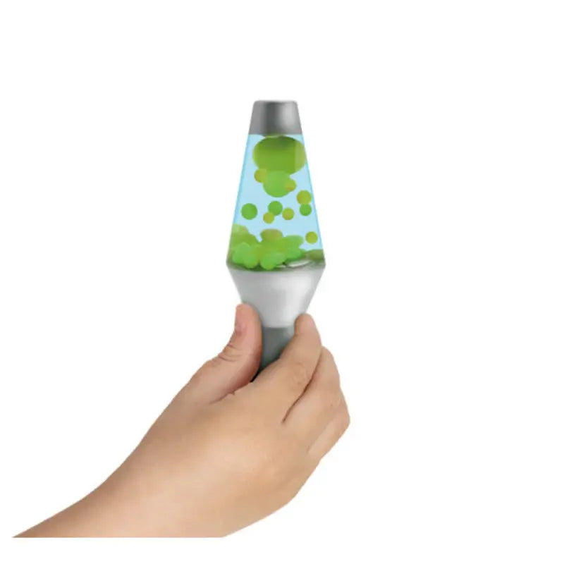 A hand holding a Lava Squish N Flow Needoh, a small silver lamp with blue liquid and floating green blobs, set against a white background.