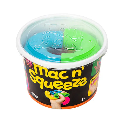 The Mac and Squeeze Needoh is a round plastic container with a clear lid, filled with colorful blue, green, yellow, and pink modeling dough. Designed for ages 3+, it mimics sensory noodles and features a label showing a hand squeezing the dough.