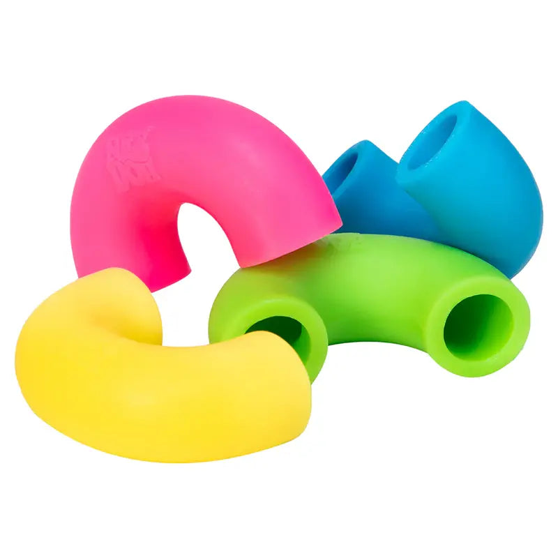 Four brightly colored, flexible silicone tubes—pink, blue, green, and yellow—are intertwined playfully on a white background, resembling Mac and Squeeze Needoh sensory noodles.