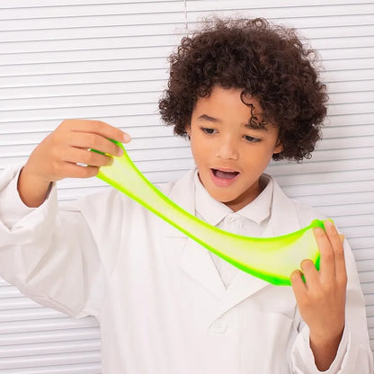 A child, excited and curious, stretches bright green, scented slime from the Sentosphere Slime Workshop while wearing a white lab coat. The background shows white horizontal lines.