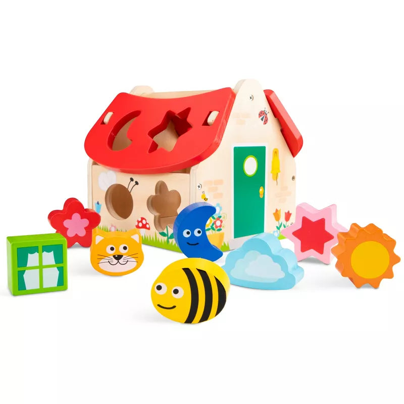A New Classic Toys Shape Sorting House with a bunch of toys around it.