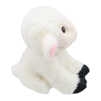 The Wilberry Eco Mini Sheep is a fluffy plush with black feet, pink inner ears, and a soft texture, sitting sideways on a white background—crafted from eco-friendly recycled materials.