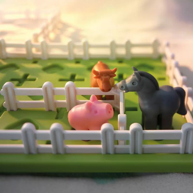 A SmartGames Smart Farmer toy farm with smart pigs and horses in a fence.
