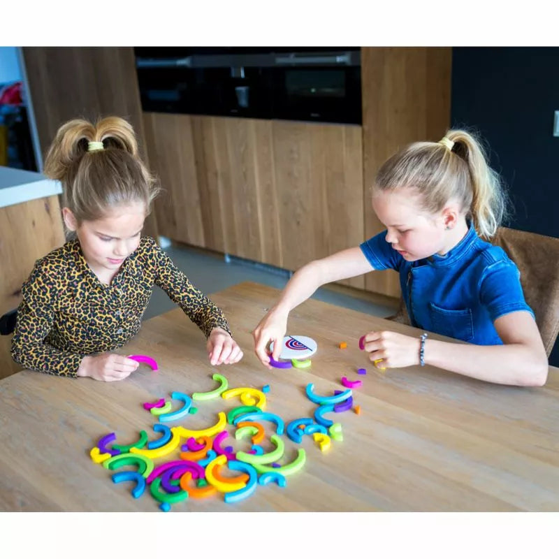 Two young girls playing with Buitenspeel Speed Bows Game on a table.