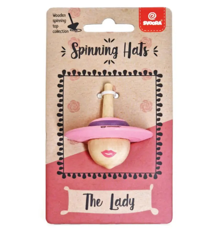 Wooden Spinning Top The Lady features a woman's face with a wide-brimmed pink hat. Its whimsical design is great for children, helping them develop fine motor skills while having fun. Comes displayed on a "Spinning Hats: The Lady" card.