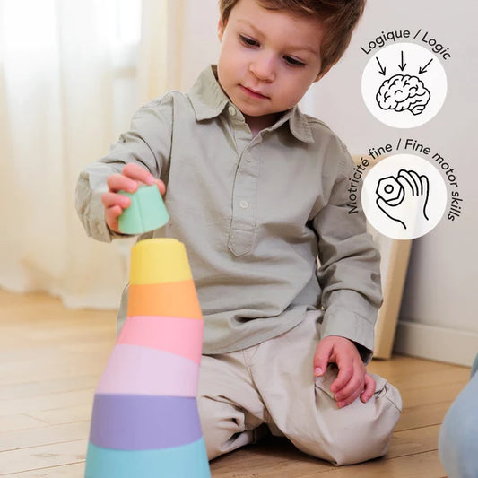 A young boy is having fun with a Stak Baby Toy, developing his fine-motor skills.