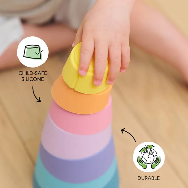 A child is joyfully engaging with the Stak Baby Toy, improving their fine-motor skills while stacking vibrant pieces.