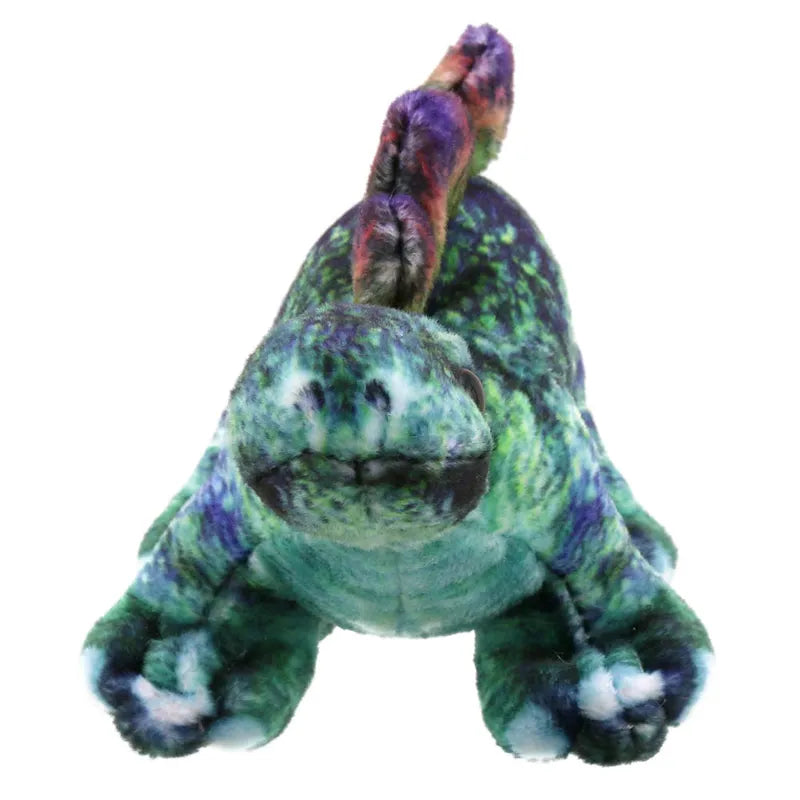 A Dinosaur Finger Puppet Stegosaurus from The Puppet Company, this plush toy resembles a dinosaur with vivid, multicolored fabric in shades of green, blue, purple, and red. It features a friendly expression with small, round eyes and numerous soft spines running along its back.