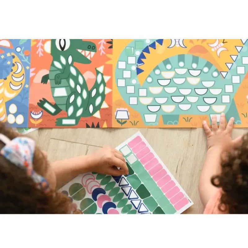 Two children have fun decorating the Poppik Sticker Panorama – Dinosaurs, using colorful stickers to create their own dinosaur poster with lively patterns on a mosaic art board while sitting on the wooden floor.