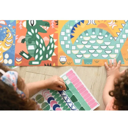 Two children have fun decorating the Poppik Sticker Panorama – Dinosaurs, using colorful stickers to create their own dinosaur poster with lively patterns on a mosaic art board while sitting on the wooden floor.