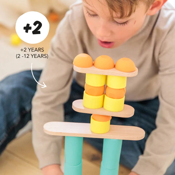 A creative young boy stacking Stix Building Games to enhance his fine motor skills.