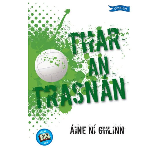 Discover the book "Thar an Trasnán" by Áine Ní Ghlinn, which boasts a cover design featuring a white volleyball with green splatter effects and titles in green text. The imagery suggests an exciting game of boys versus girls. Additionally, you'll find The O'Brien Press logo in the top right corner and a small blue circle labeled "grád 2.