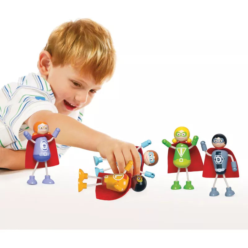 A young boy with red hair is happily playing with the Superhero Figure Pack featuring poseable arms and legs against a white background.
