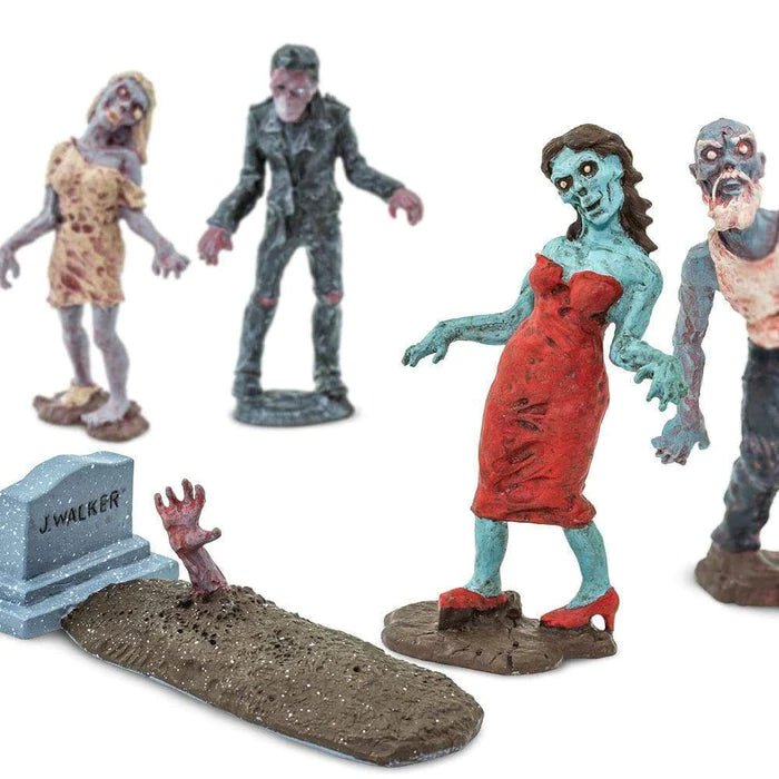 a group of TOOBS® Figurines Zombies standing next to a grave.