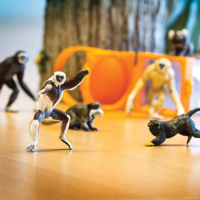 a group of TOOBS® Figurines Primates on a wooden table.
