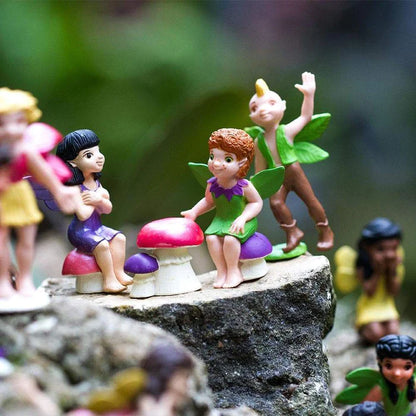 a group of TOOBS® Figurines Friendly Fairies sitting on a rock.