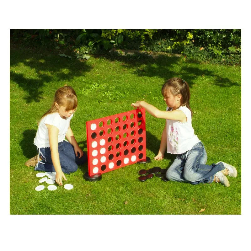 Two little girls playing with Giant Garden Game Four in a Row.