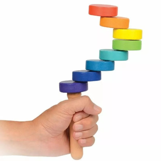 a hand holding a SmartGames TrueBalance Compact (8 discs) that has a rainbow of colors.
