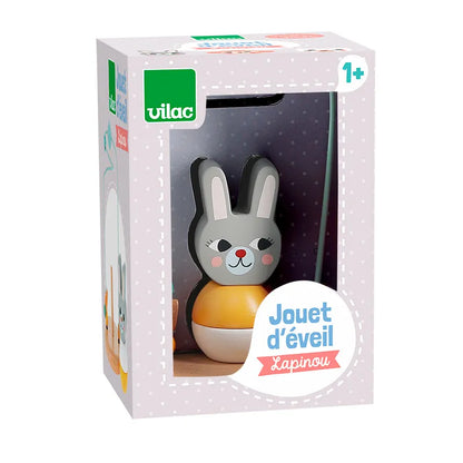 The Vilac Early Learning Game Little Rabbit is an enchanting wooden toy designed for children aged 1 and above. It features an adorable grey bunny with pink cheeks sitting atop a yellow base. The packaging includes a clear front window that highlights the bunny inside, adorned with the text "Jouet d'éveil Lapinou." This delightful toy is perfect for little ones from the age of 1.