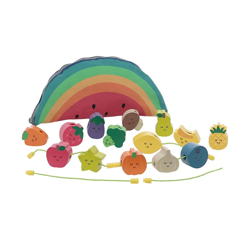 The Vilac Fruits Wooden Beads set features a large, colorful wooden rainbow with a smiley face. In front of it, there are various smiley fruit and vegetable pieces, including grapes, strawberries, a pineapple, and more. Perfect for kids 18 months and up, the set includes a green string for threading the pieces.