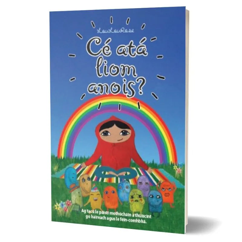 The image shows the cover of a set of 10 A6 cards titled "Cé atá liom anois?" featuring an illustrated child wearing a red hooded outfit in front of a rainbow. Below them are colorful creatures with various expressions, promoting emotional understanding. The background is a blue sky with suns and rays.