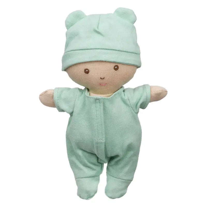 The Wilberry Baby Doll in Green Outfit comes with a basket and blanket. Dressed in light green with a matching bear-ear hat, this soft doll features an embroidered face with brown eyes and a small smile—perfect for snuggles and gentle play.